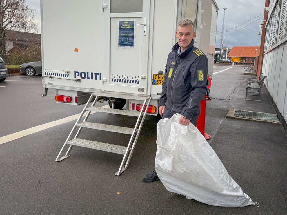 Mand tager en papkasse ud af bagagerummet