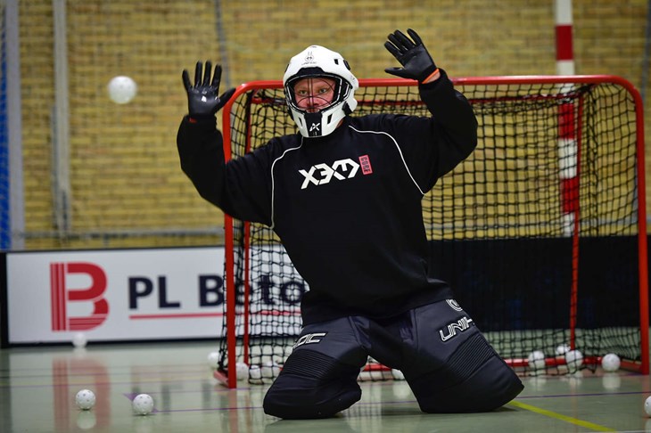 I floorball spiller m&aring;lvogteren med hjelm.
