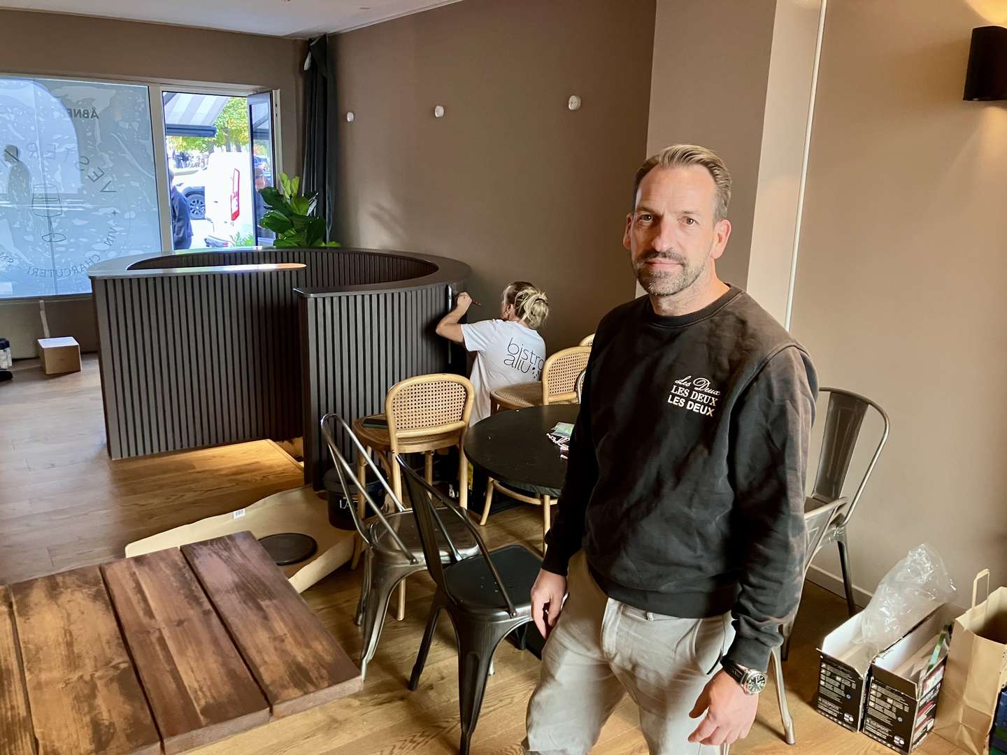 Casper J. Johansen og siddende medejer Stina Øksenhøj Madsen, som arbejder utrætteligt med penslen – og på ryggen reklamerer for Bistro Ailu i Zoologisk Have.