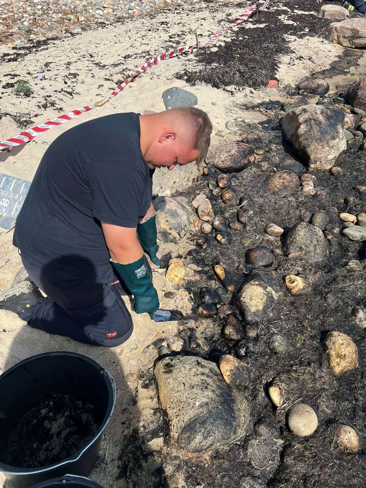 Fire frivillige og mandskab fra brandv&aelig;snets station i R&oslash;nne rensede mandag stranden i Sose for olie. Foto: Bornholms Brandv&aelig;sen