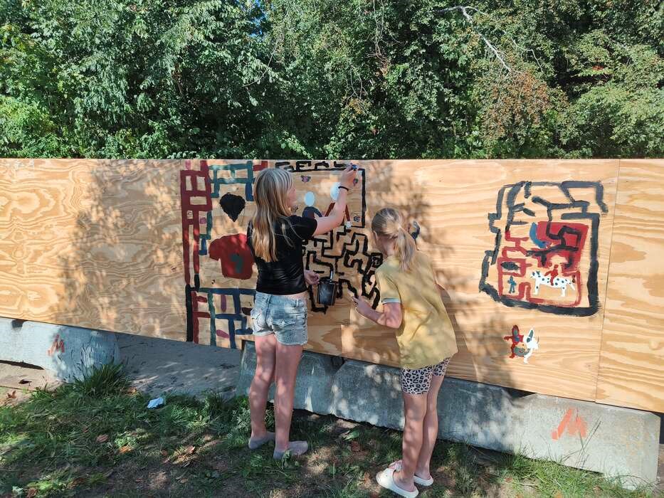 Skoleb�rn dekorerer byggepladshegn