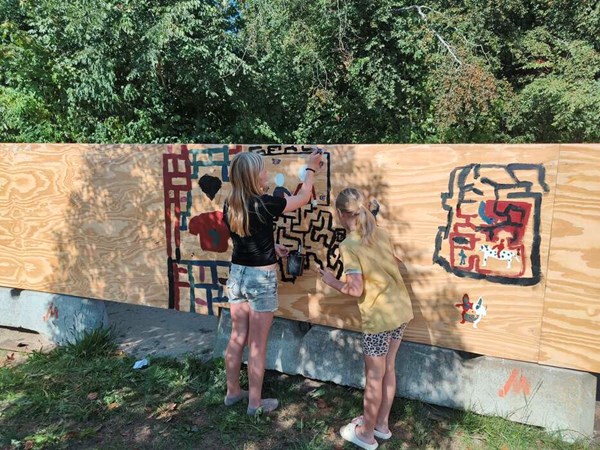 Skoleb�rn dekorerer byggepladshegn